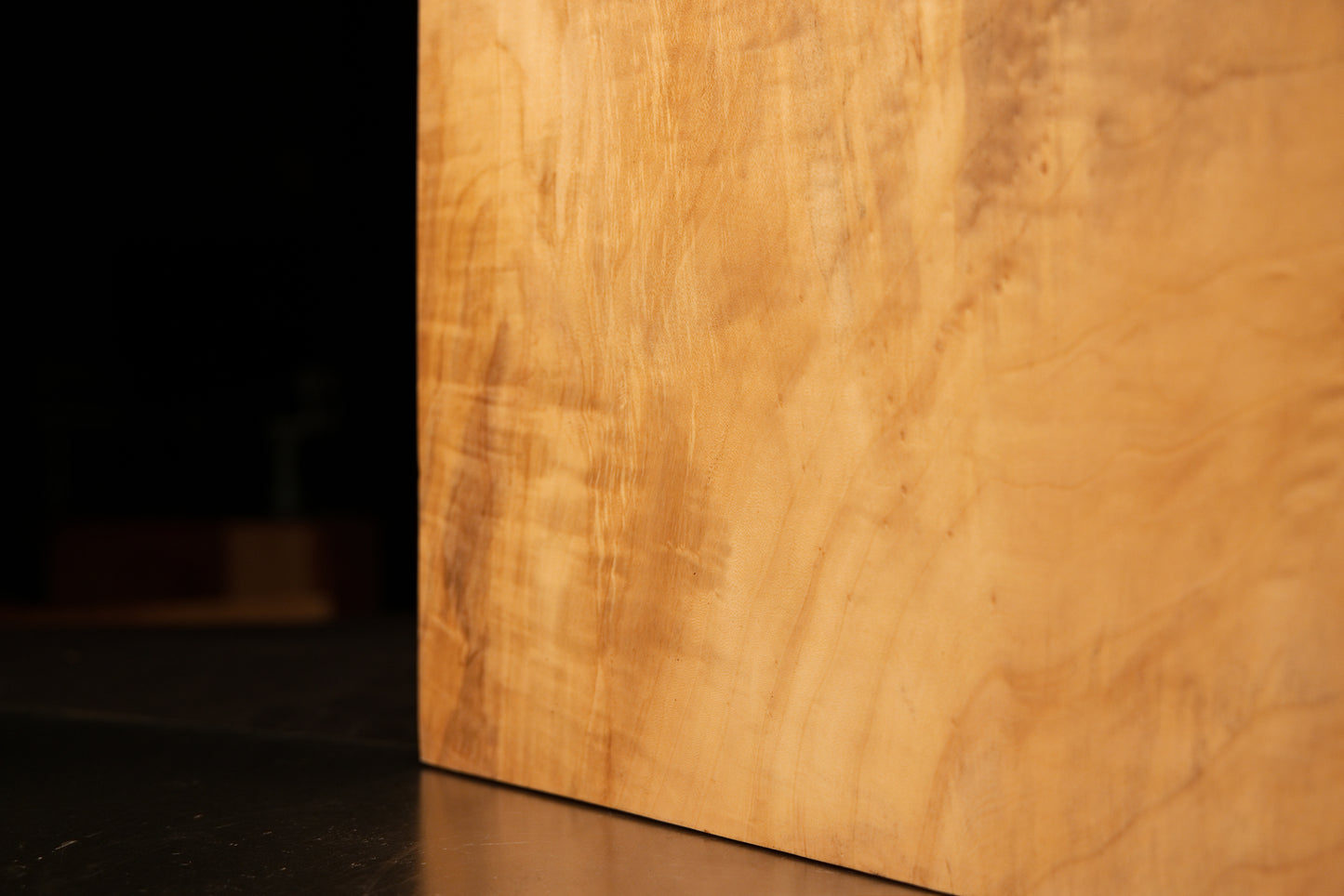 Lower corner profile displaying a pristine flat cut meeting heavily patterned sweeping grain on an epoxy-free wooden structure.