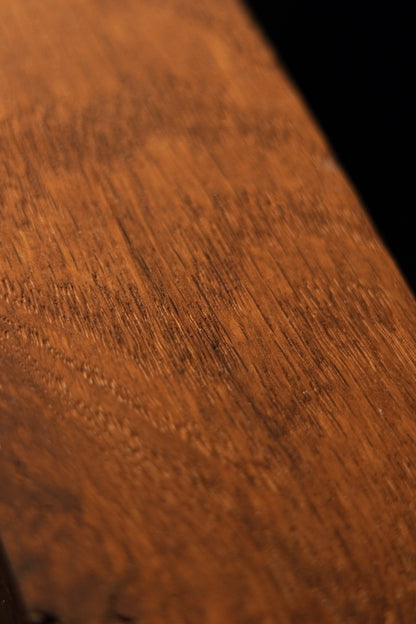 Extreme macro shot revealing the deep cellular thermal modification and rich chatoyant grain texture of the biophilic wood art. 