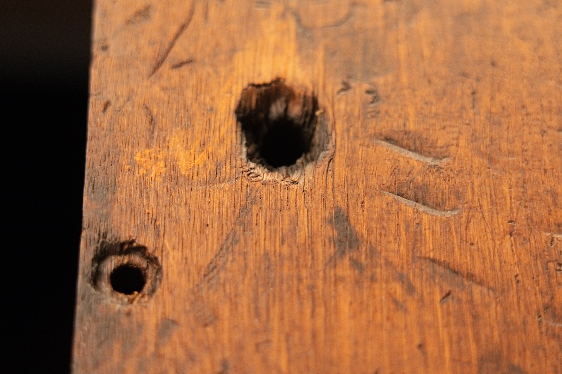 Macro photography of the untreated epoxy-free timber surface revealing historical tool marks and an authentic joinery cavity. 