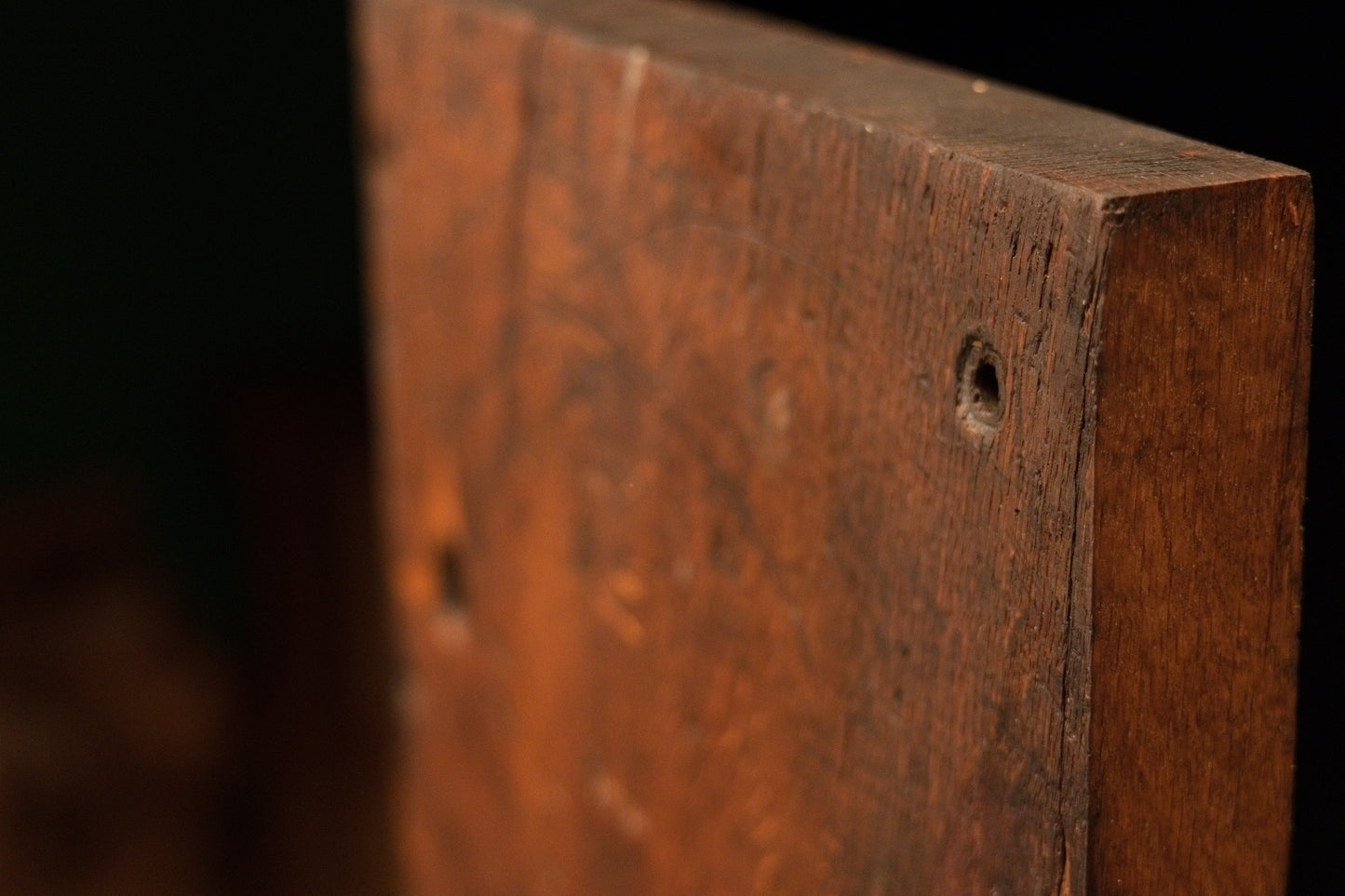 Upper reverse corner detail of the climate-proof architectural timber block displaying a single historical structural wood void. 