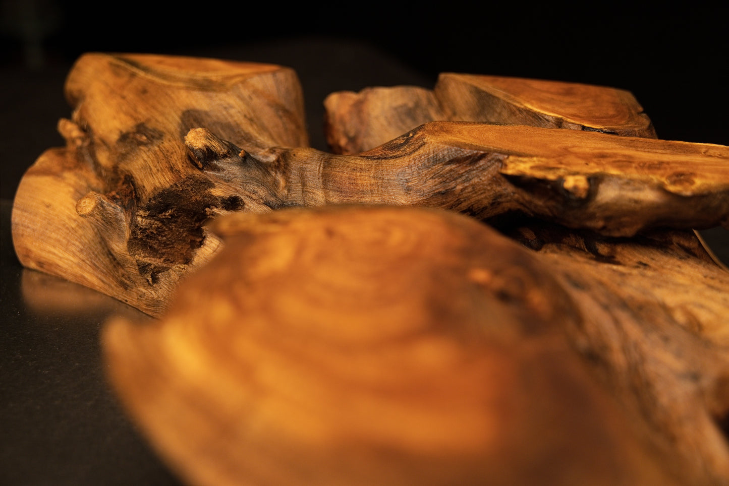 Low-angle macro view looking across polished organic wooden curves and precision cut sections of the medium oak root art piece.