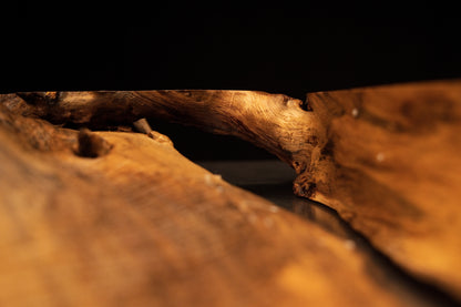 Close-up view of the structural timber intersection showing natural grain continuity across the solid medium oak root sculpture.