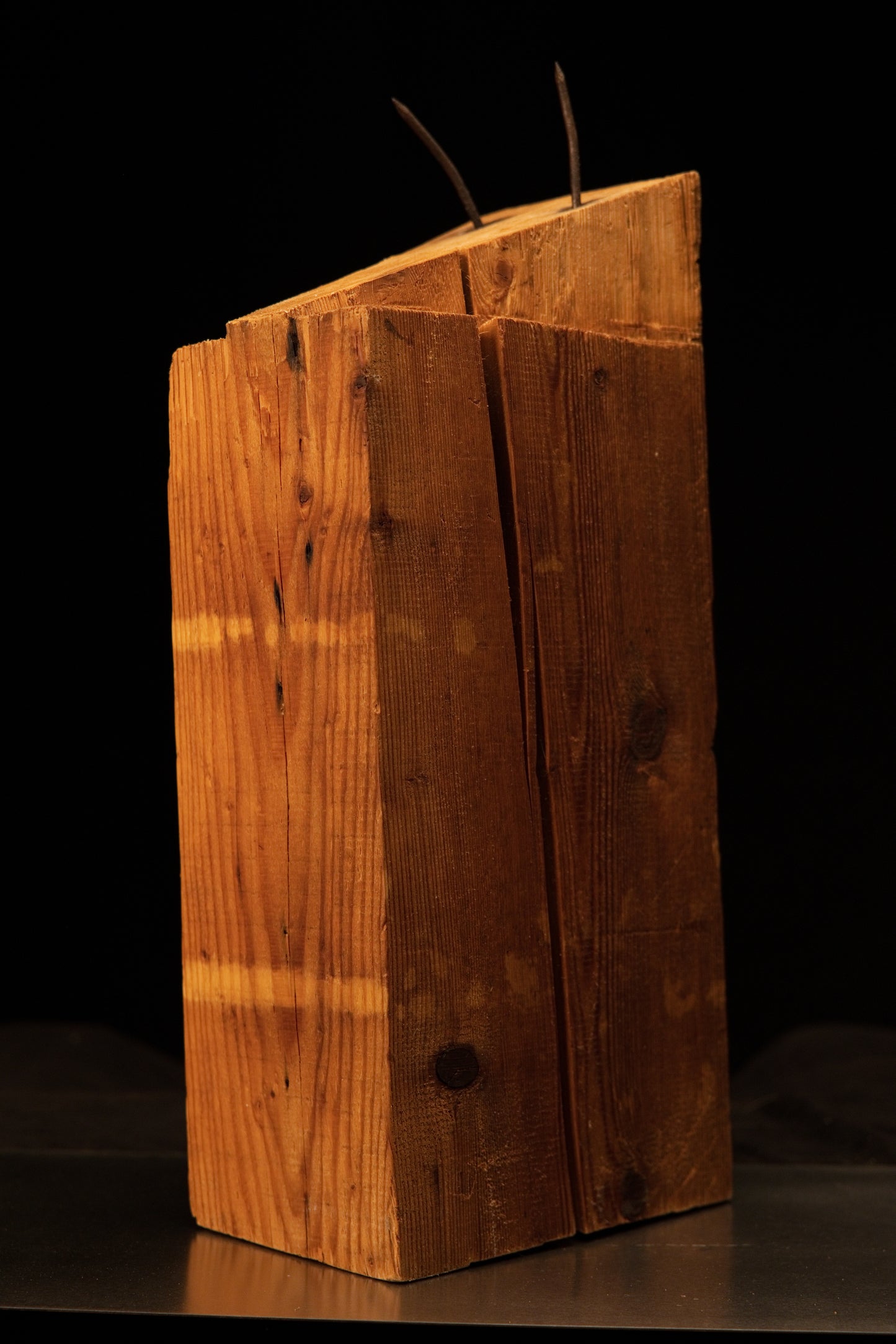 Front view of a relic-grade architectural heritage beam featuring a slanted top cut and embedded historic rusted metal spikes.   
