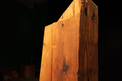 Upper angled profile of a climate-stable architectural salvage beam highlighting the precision cut top and dark structural knots.   