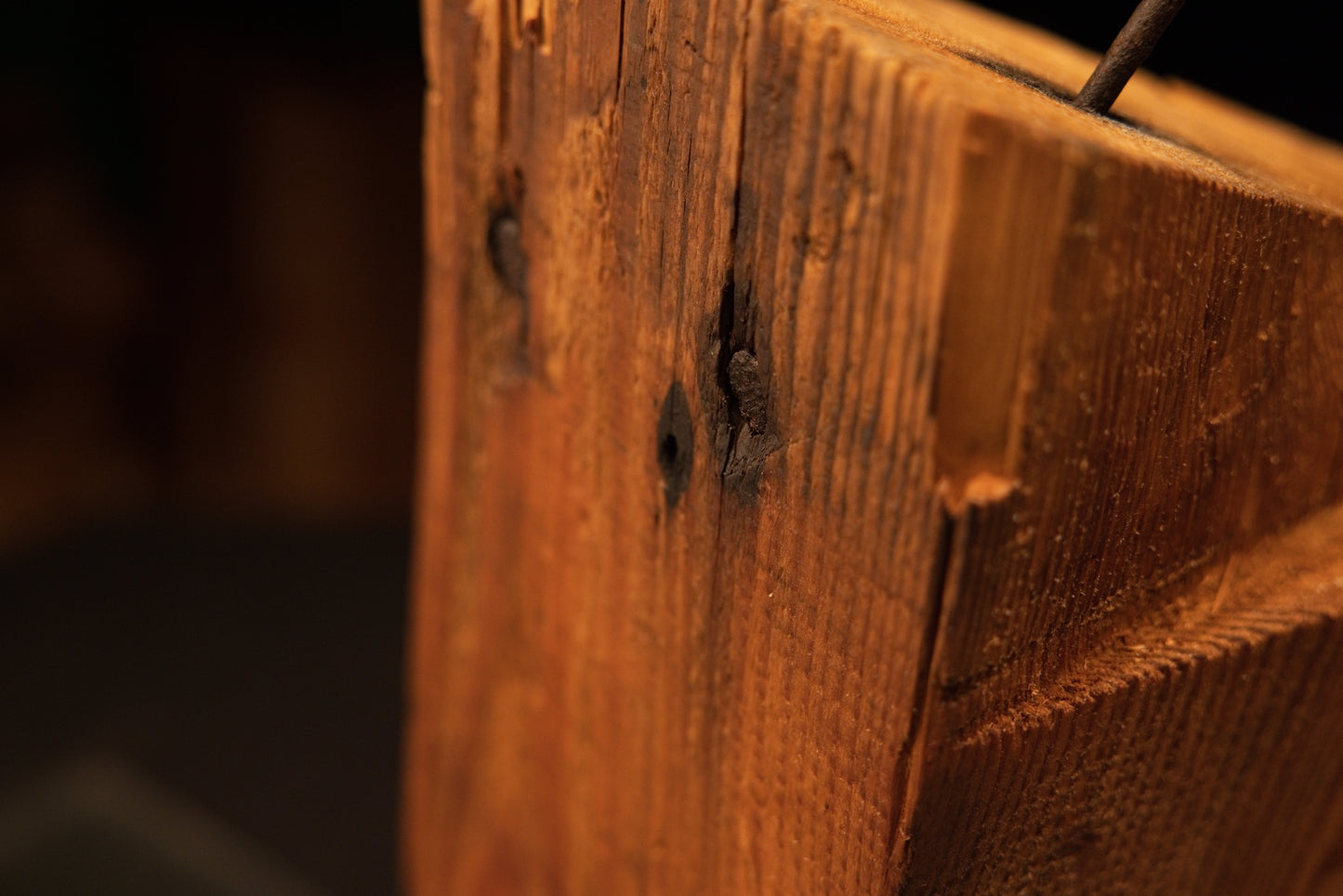 Extreme macro of dark historical nail cavities embedded within an epoxy-free biophilic structural beam for luxury architecture.   
