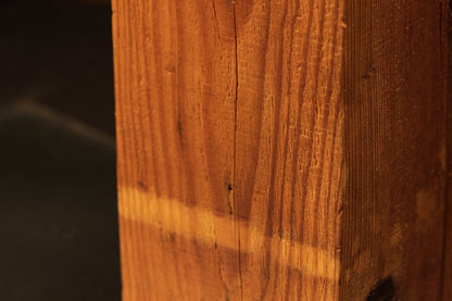 Macro focus on a distinct horizontal pigmentation band across the vertical grain of an authentic architectural salvage wood beam.   