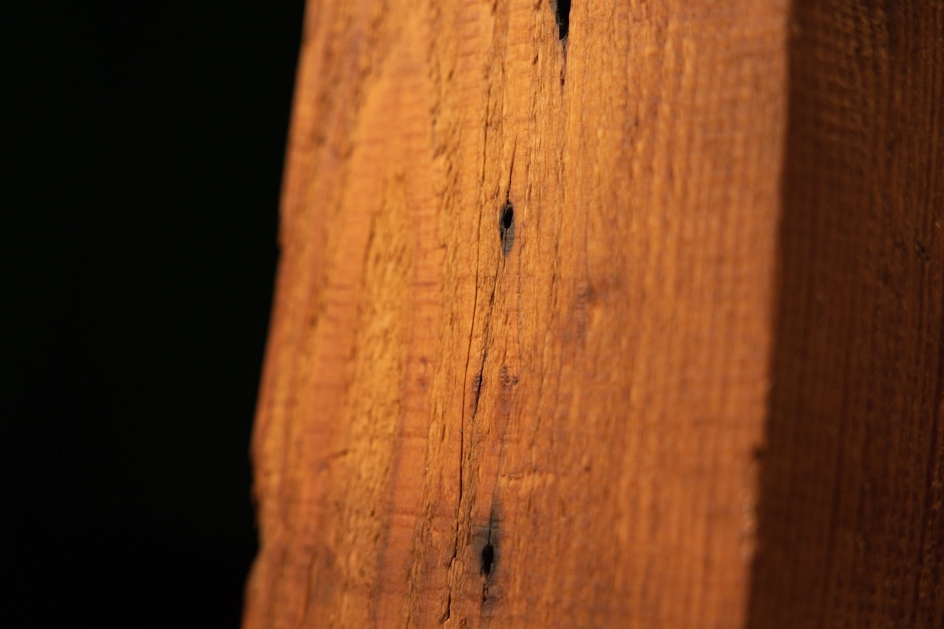 Vertical close-up of a climate-proof heritage beam highlighting perfectly stabilized micro-cracks and authentic joinery voids.   