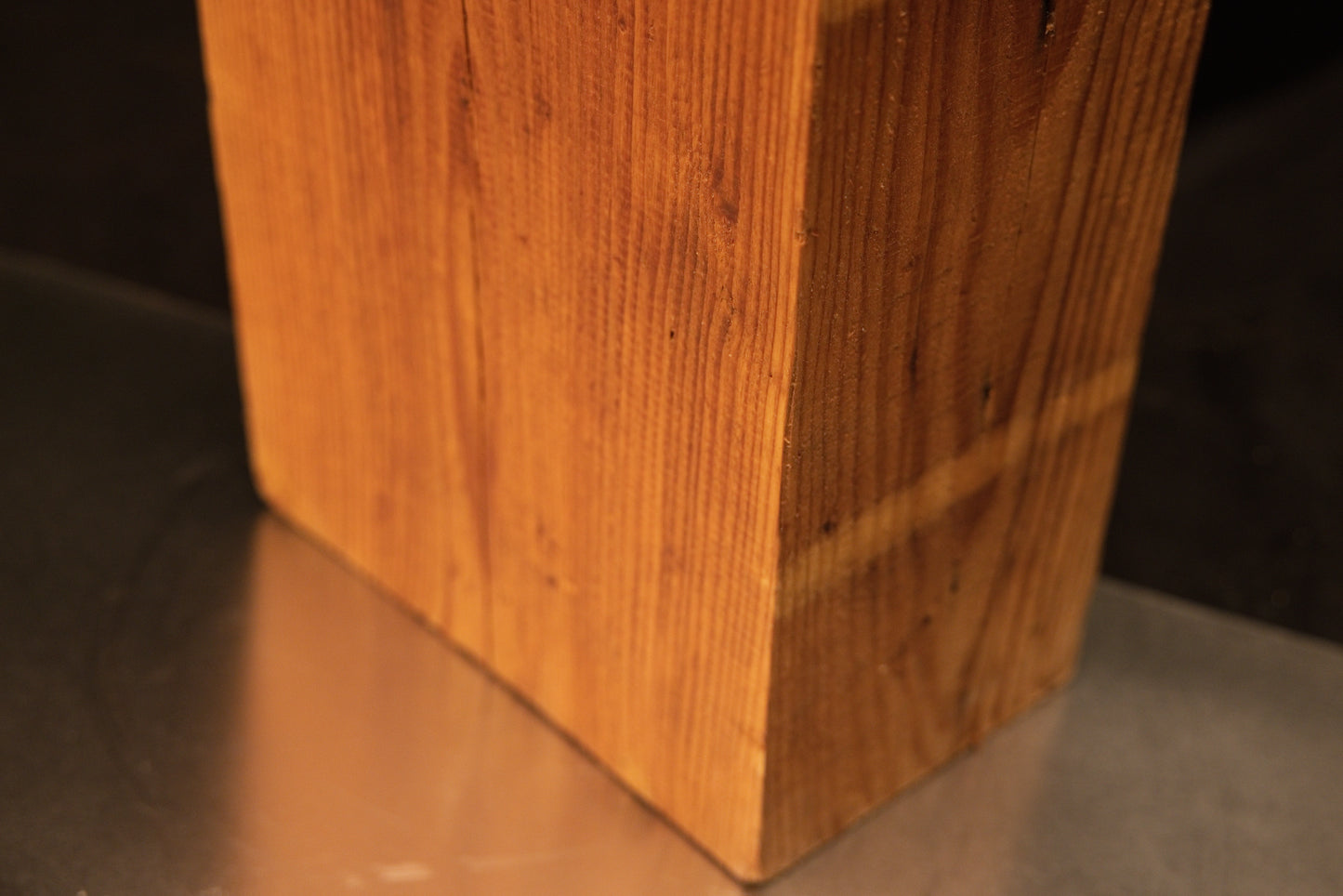 Lower corner perspective of a botanical relic revealing a distinct horizontal patina band over vertical grain.   