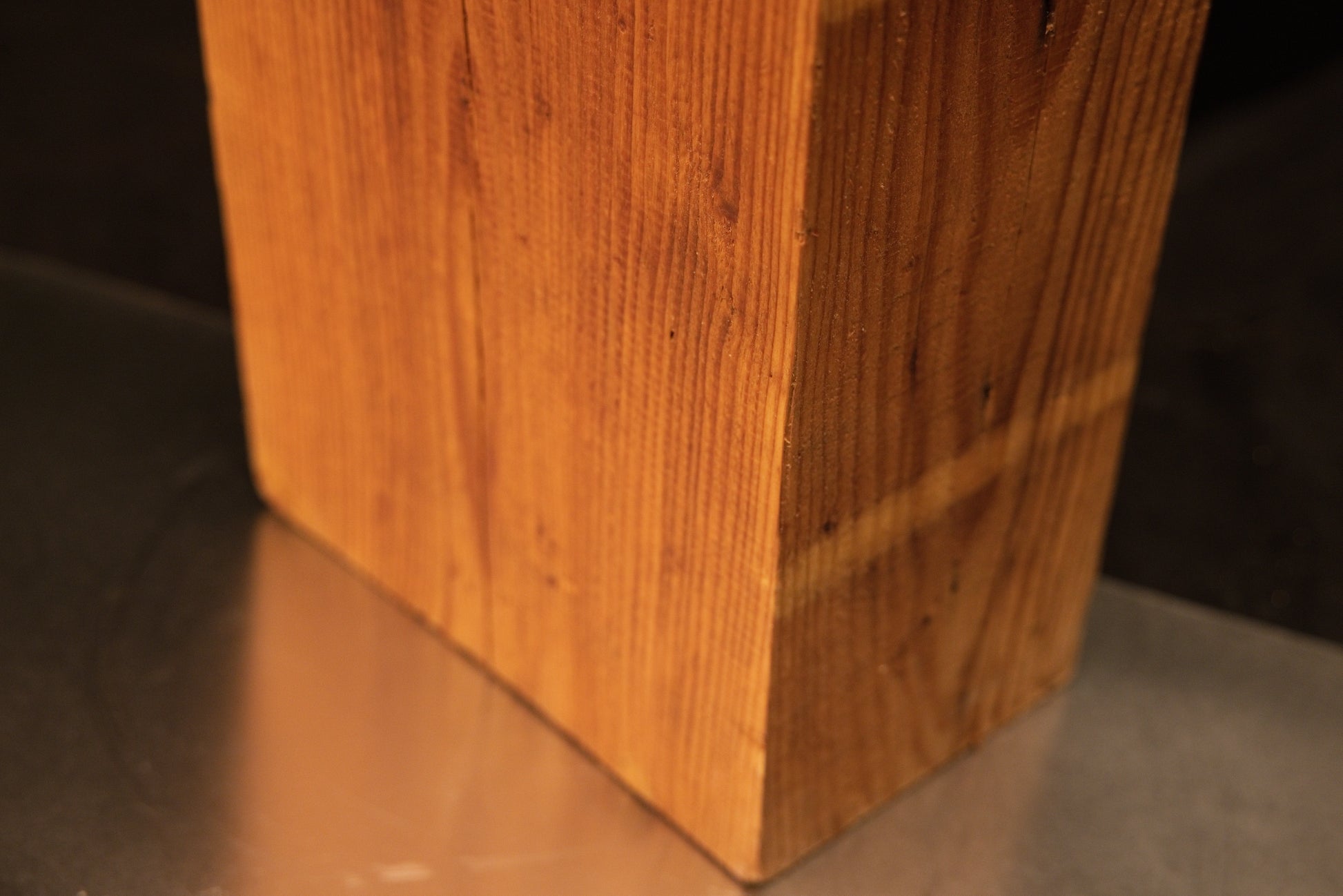 Lower corner perspective of a botanical relic revealing a distinct horizontal patina band over vertical grain.   
