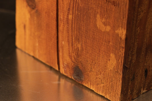 Lower side profile of a relic-grade historic European timber block emphasizing straight vertical grain and raw organic geometry.   