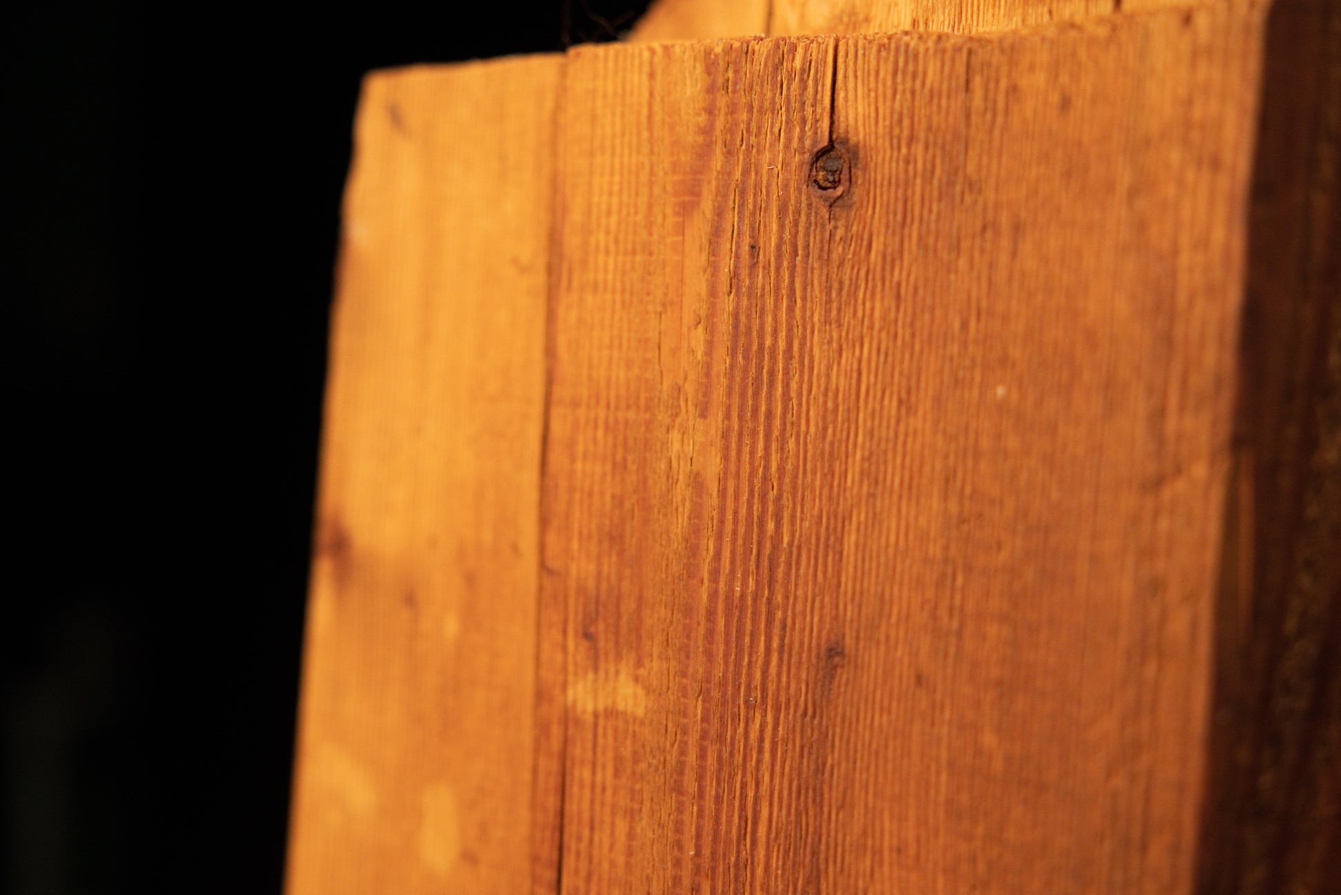 Upper profile detail of a climate-stable architectural salvage piece revealing a small joinery void and stabilized natural check.   