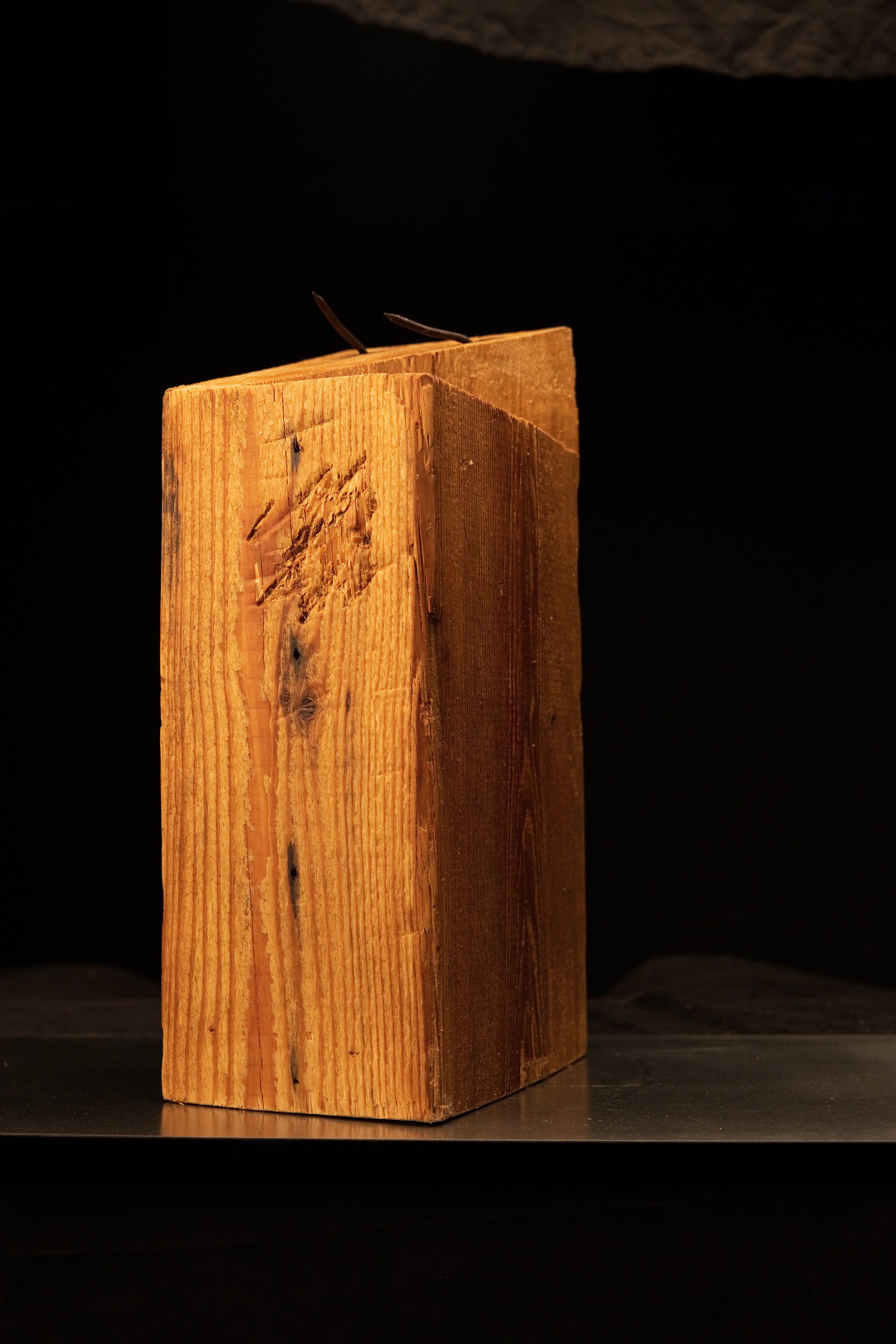 Full standing profile of a museum-grade architectural salvage wood block emphasizing original surface scoring and iron nails.   