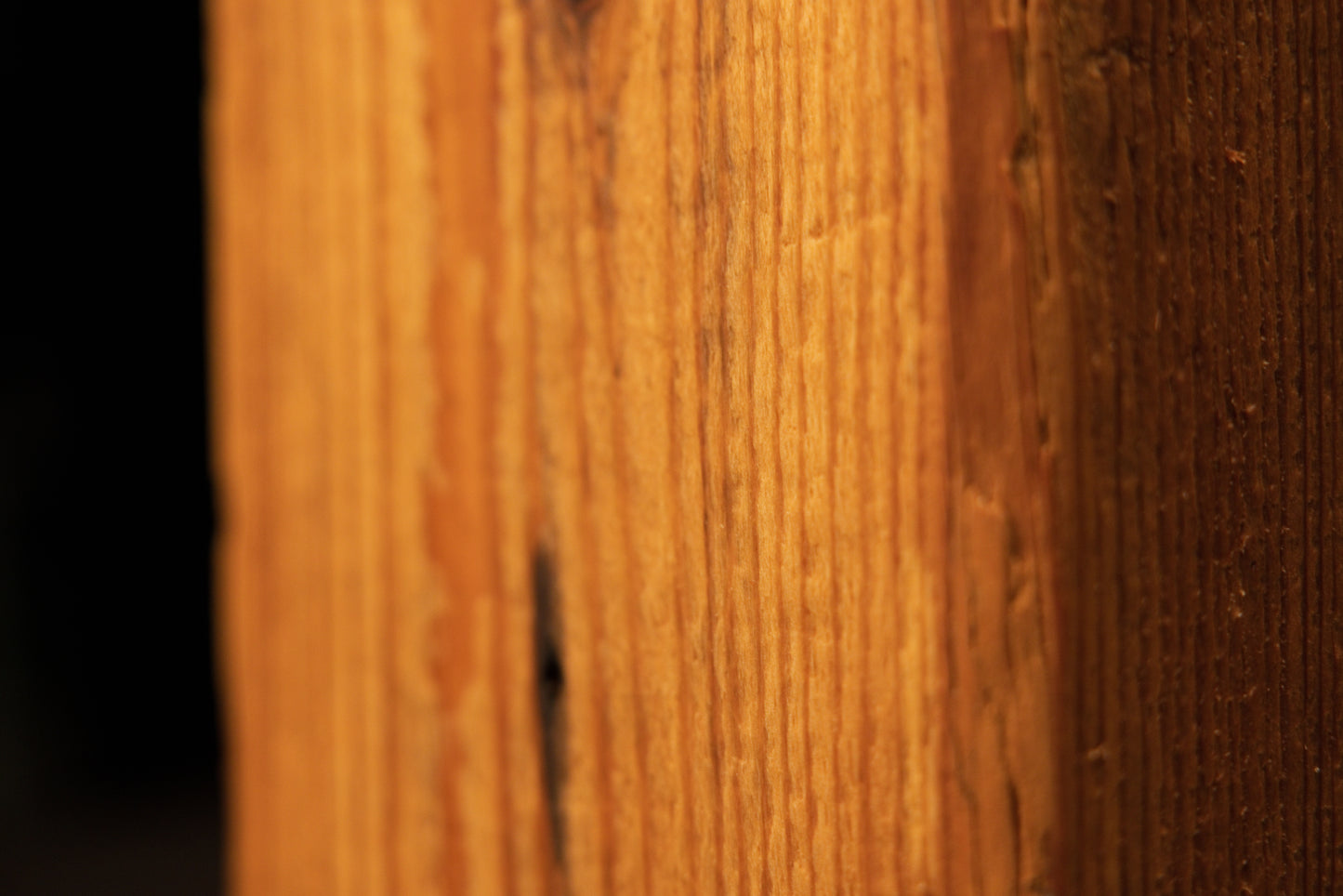 Detailed view of the flat face on a century-old heritage beam demonstrating pristine vertical wood grain and non-toxic finish.   