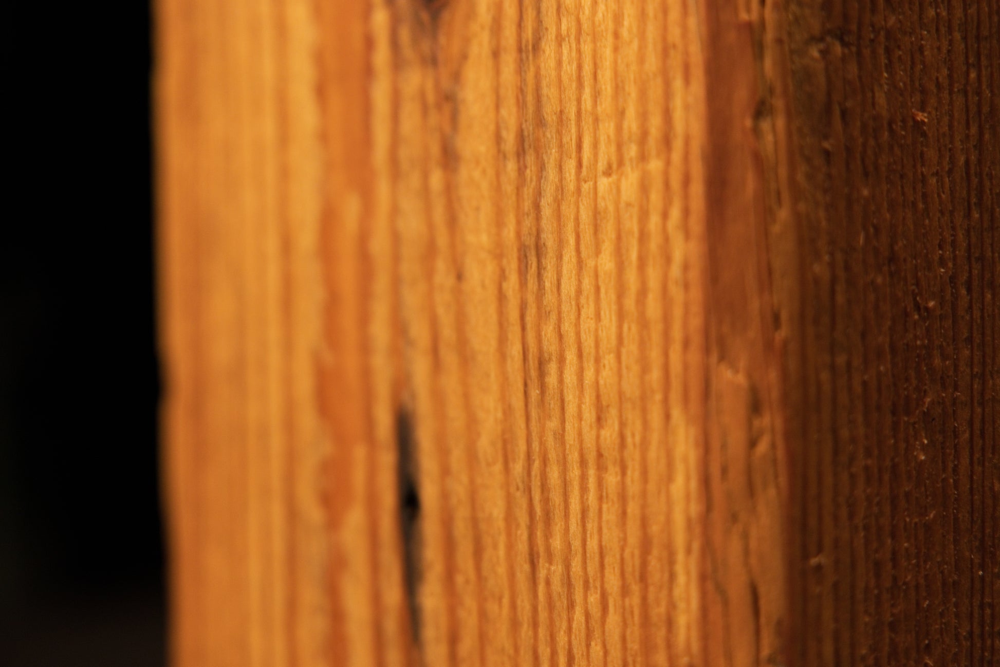 Detailed view of the flat face on a century-old heritage beam demonstrating pristine vertical wood grain and non-toxic finish.   