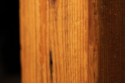 Detailed view of the flat face on a century-old heritage beam demonstrating pristine vertical wood grain and non-toxic finish.   