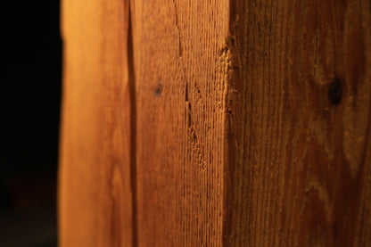 Macro perspective of fine vertical grain patterns on a solid biophilic interior wood block highlighting true original patina.   