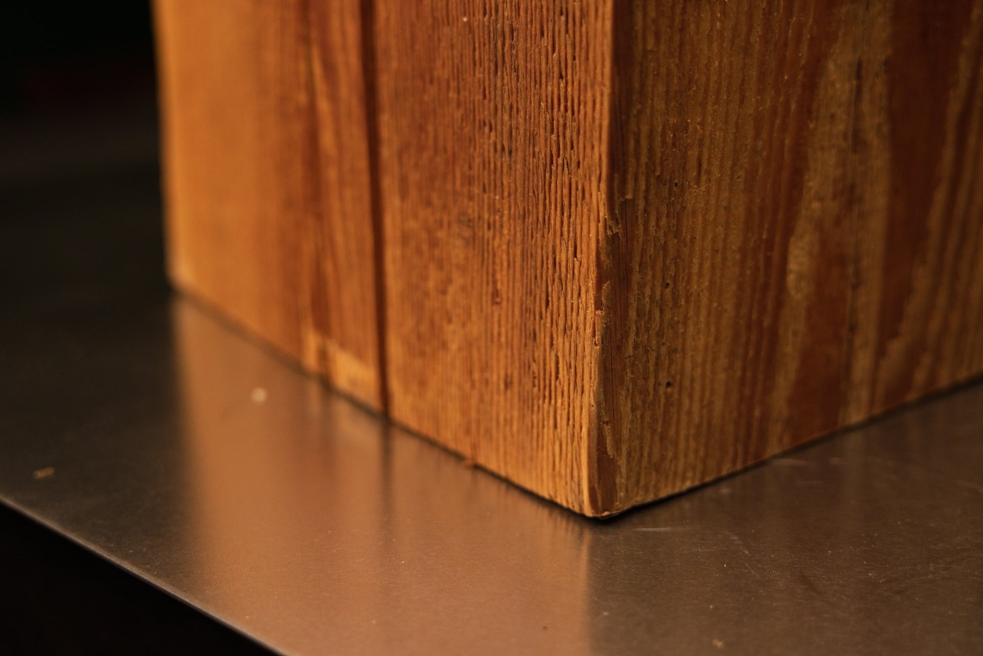 Lower corner view where the stabilized historic wooden monolith meets the surface demonstrating absolute dimensional stability.   