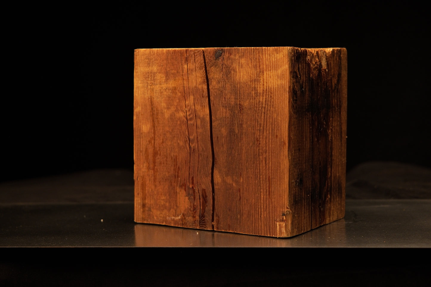 Front angled view of a square relic-grade structural timber block featuring a deep vertical face crack and dark oxidized side.[cite: 1, 3]