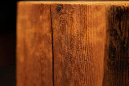 Lower right corner of a structural historic timber block highlighting the transition from vertical golden grain to a dark face.[cite: 1, 3]