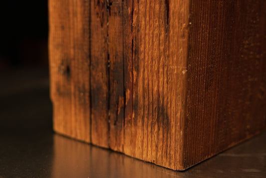 Close-up detail of the heavily weathered dark oxidized face on a climate-stable architectural salvage block revealing true patina.[cite: 1, 3]