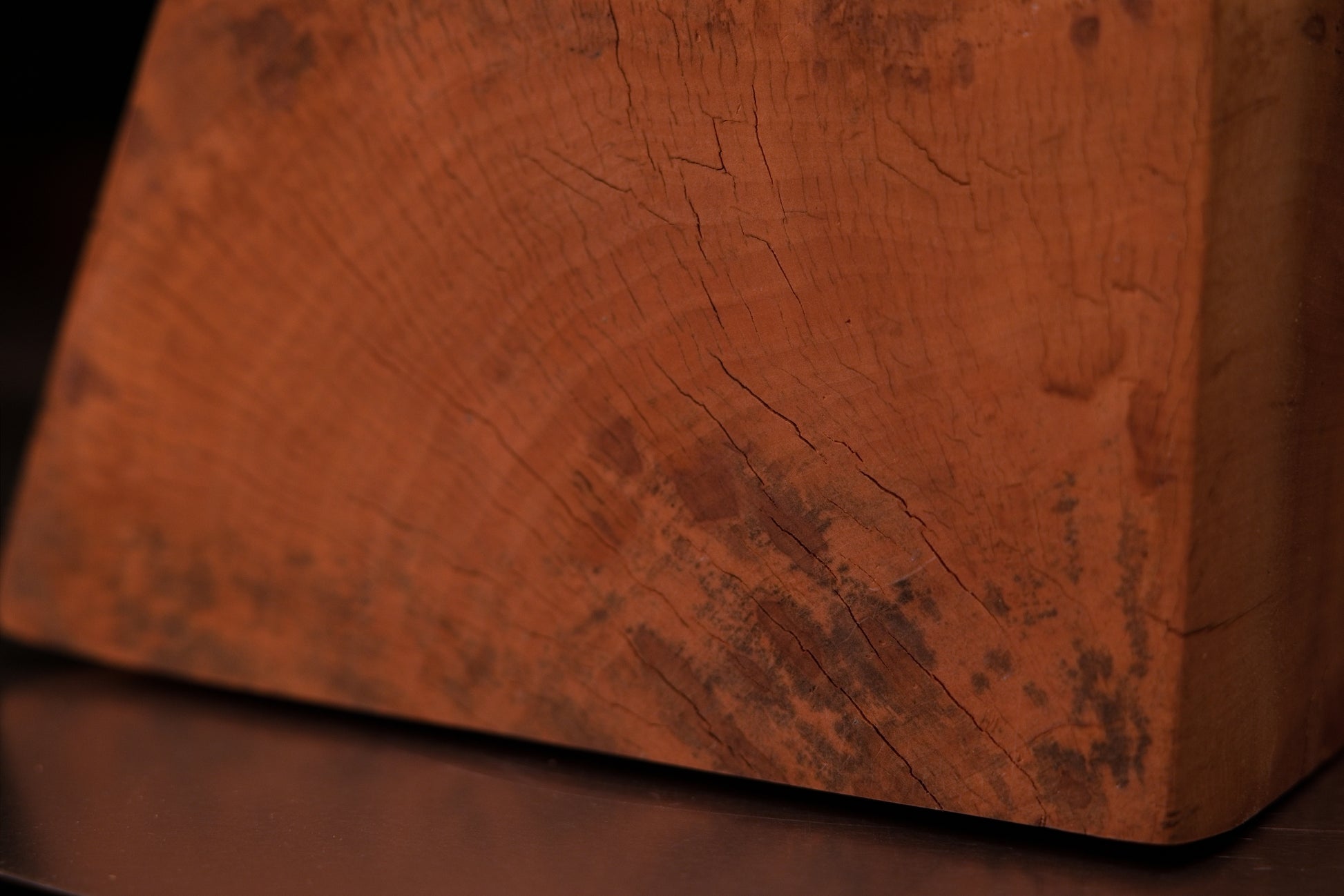 Macro photography of a museum-grade architectural wood surface showcasing wavy golden grain and unique biological pigmentations.   