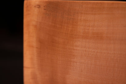 Vertical side view of an epoxy-free botanical wood monolith highlighting a striking dark flame grain pattern and smooth finish.   