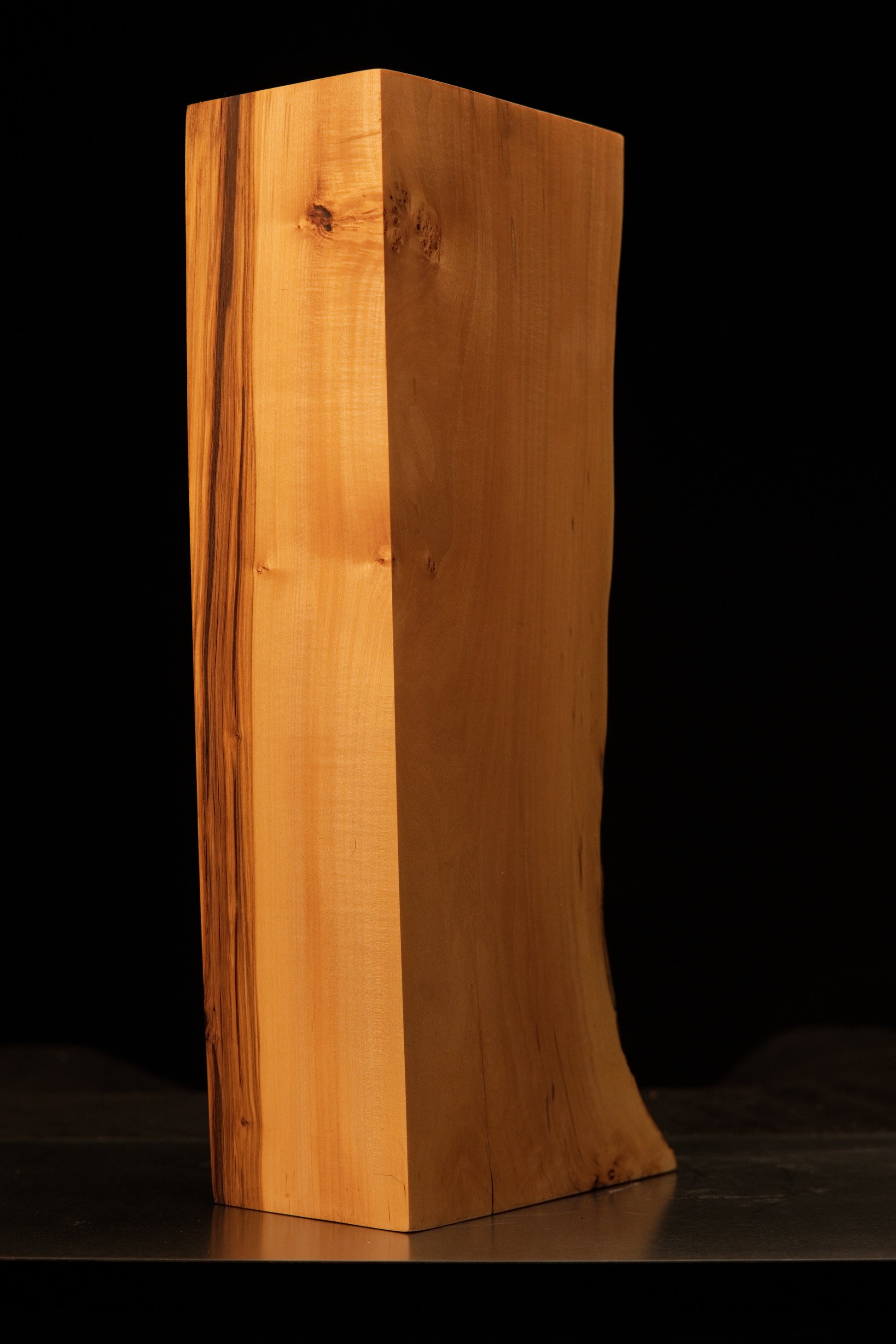 Detailed view of the polished architectural wood face featuring distinct dark biological pigmentations and flawless texture.   