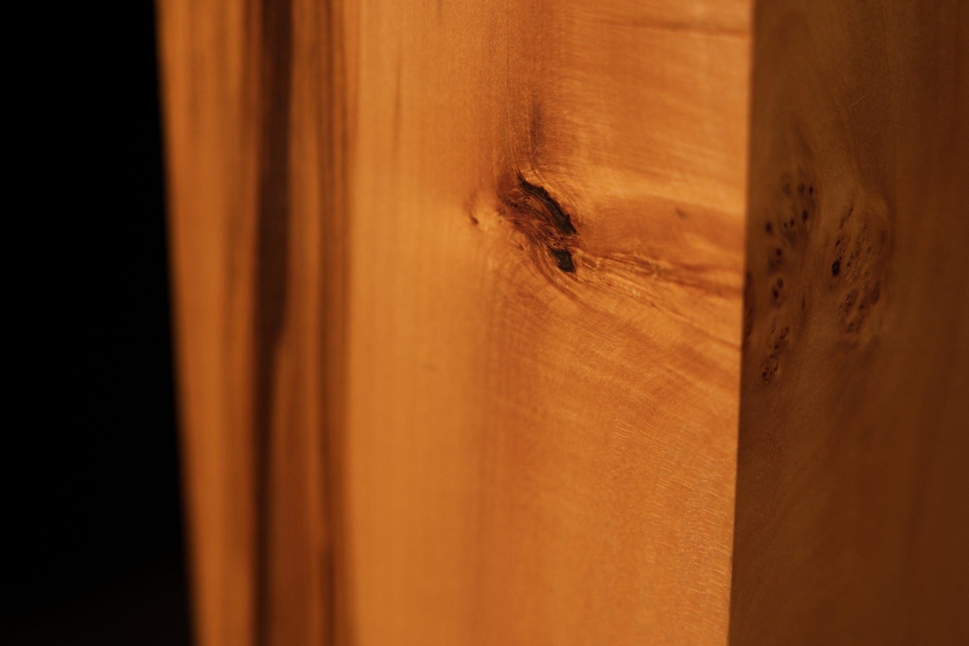 Close-up of natural hairline vertical cracks perfectly stabilized within the smooth face of the biophilic structural timber.   