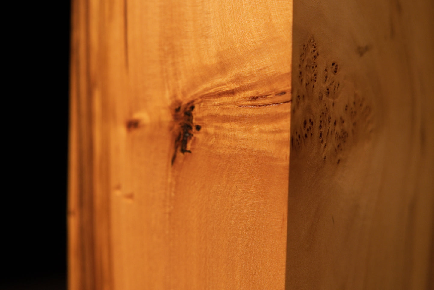 Extreme macro of tight birdseye grain clusters on a polished Relic-Grade wood surface highlighting unique organic textures.   