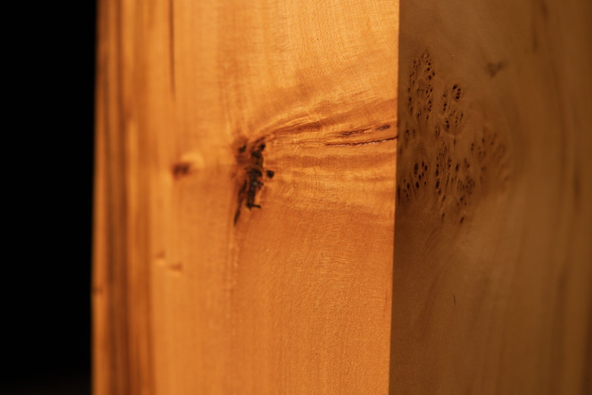 Extreme macro of tight birdseye grain clusters on a polished Relic-Grade wood surface highlighting unique organic textures.   