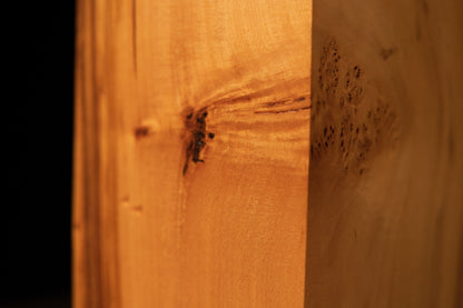Extreme macro of tight birdseye grain clusters on a polished Relic-Grade wood surface highlighting unique organic textures.   