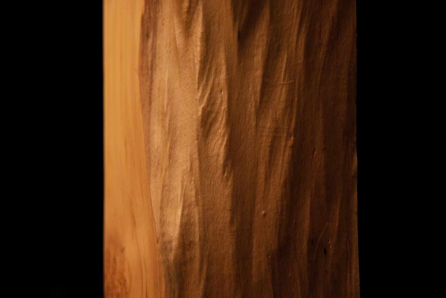 Close-up on the crisp edge boundary separating the flat precision cut side and the wavy organic face of the heritage timber.   