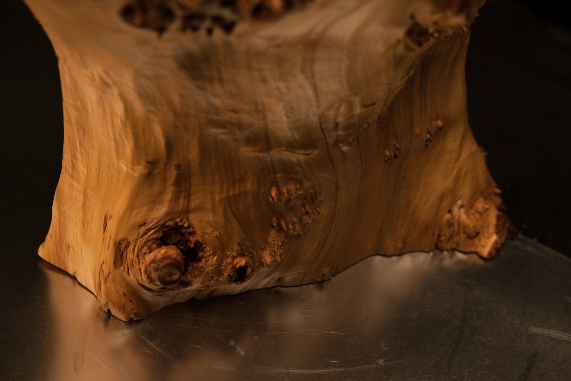 Detailed macro view focusing closely on smooth vertical grain lines gently interrupted by small natural wood knots and tiny pits.   