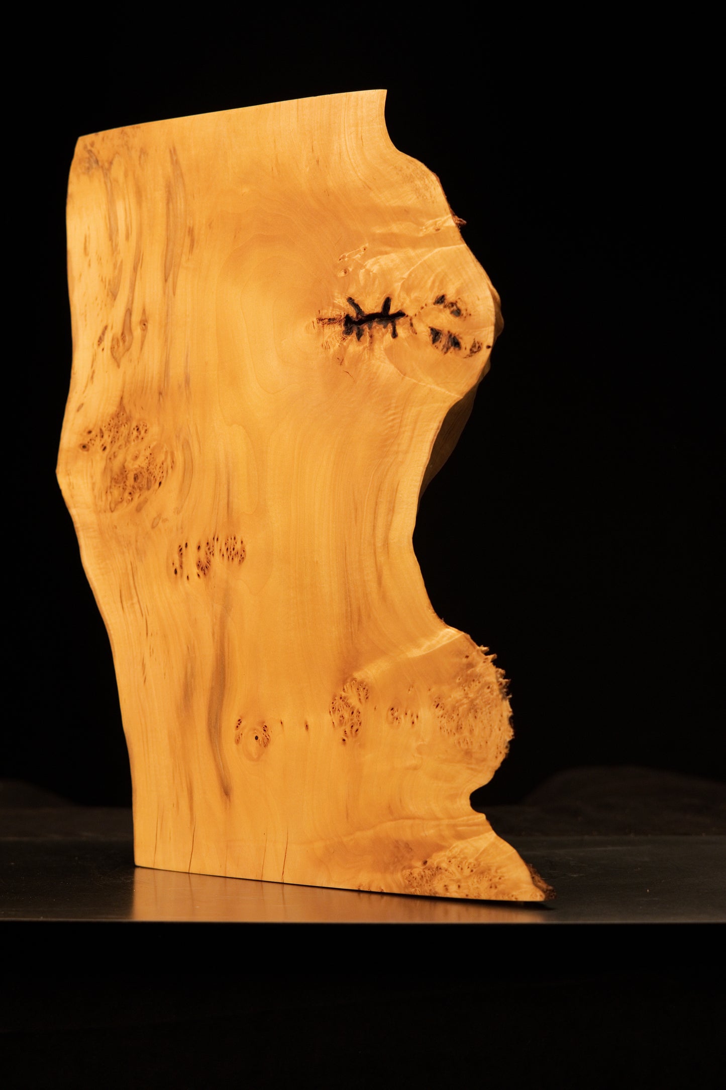 Close-up of the smooth top corner on an epoxy-free structural monolith contrasting precision cuts against natural biological grain.   