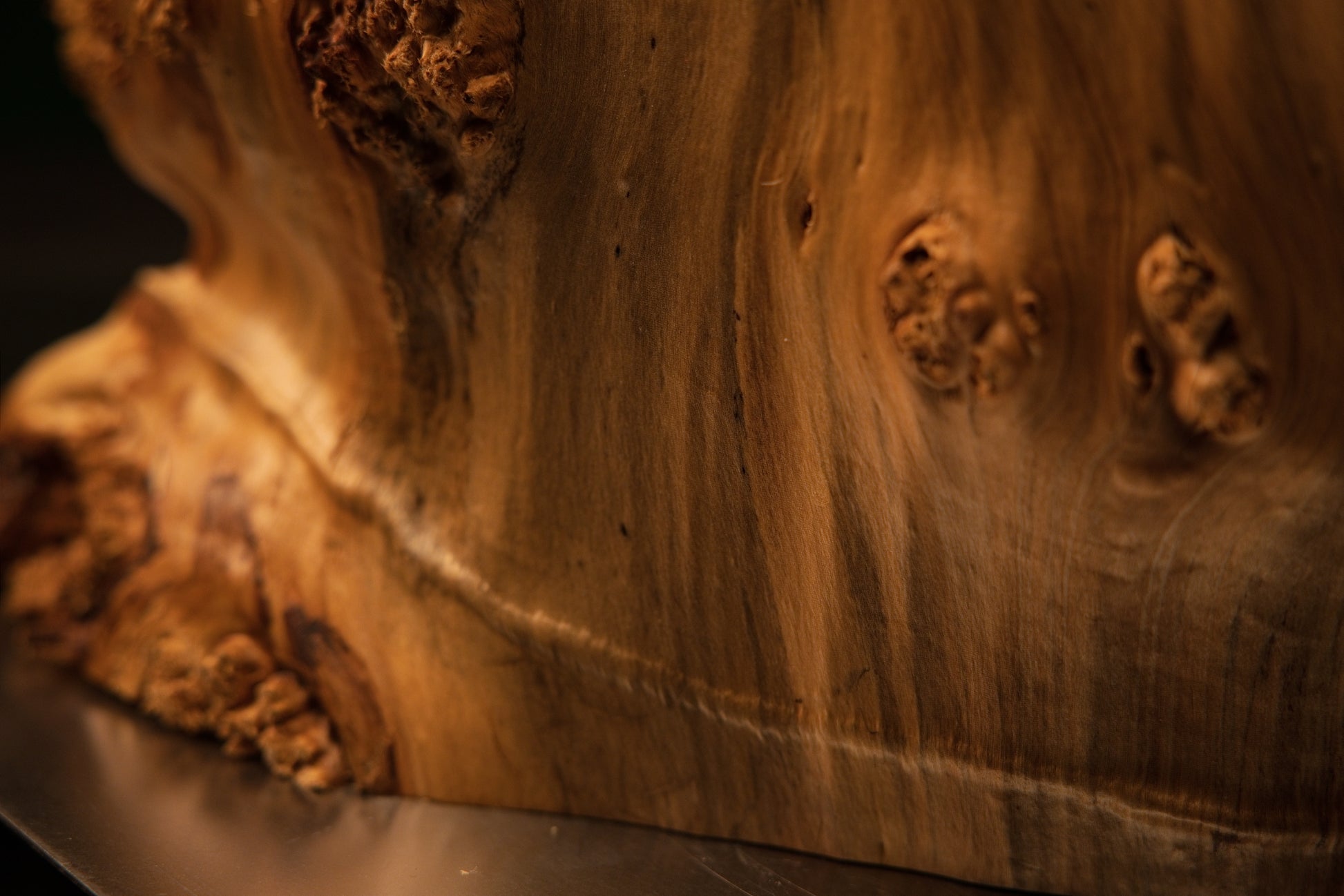 Extreme macro of a dark jagged horizontal void inside an epoxy-free architectural timber element showing true organic geometry.   