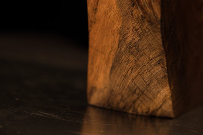 Close-up capture of swirling golden-brown wood patterns demonstrating natural light reflection on a polished slab face.   