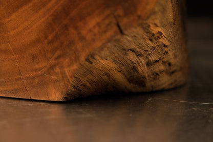 Side perspective showing the clean geometric bottom boundary of a weather-resistant wooden art block with linear grain.   