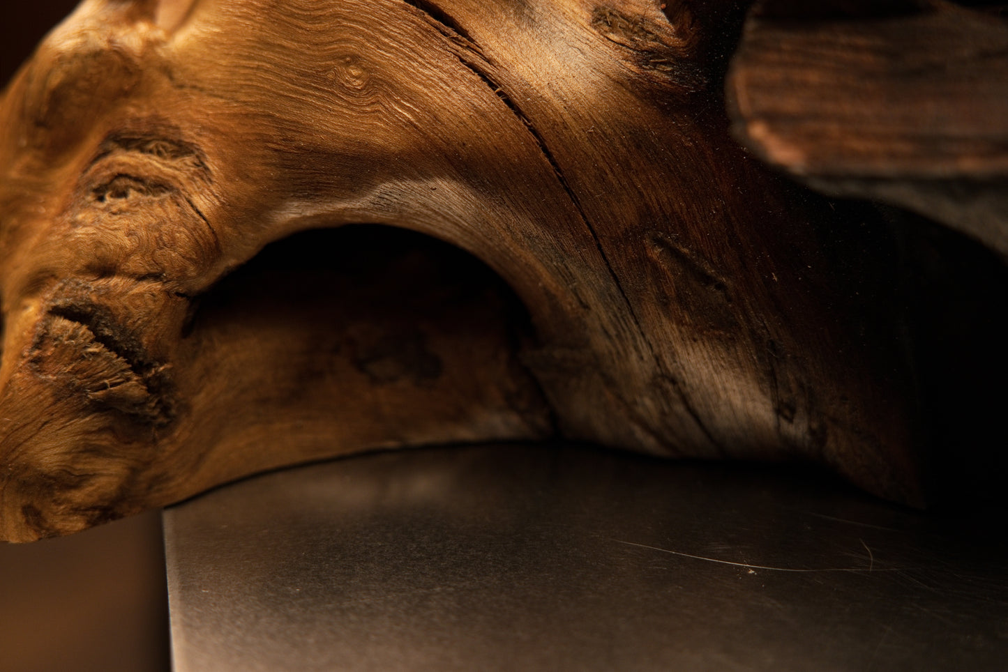 Detailed base corner view highlighting a dark arched void and smooth golden grain resting securely on a flat structural plane.   