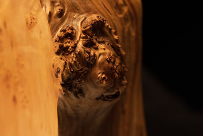 Intimate perspective of a large protruding burl cluster on an architectural heritage wood piece demonstrating raw botanical mass.   