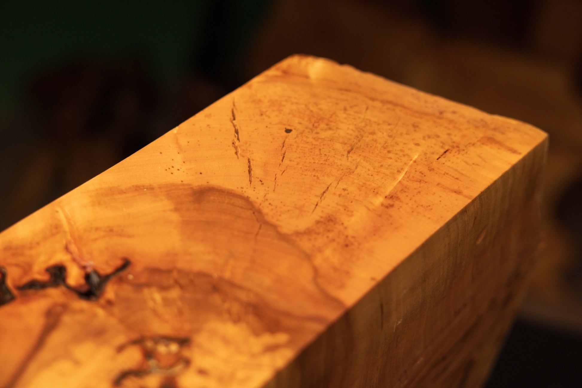 Macro focus pointing out a distinct dark organic knot embedded within the perfectly flat top surface of a floor-heating safe wood element.   