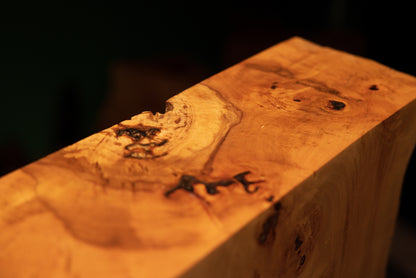 Close view of the top corner where a precision-cut horizontal plane meets the rugged organic side of a heritage timber artifact.   