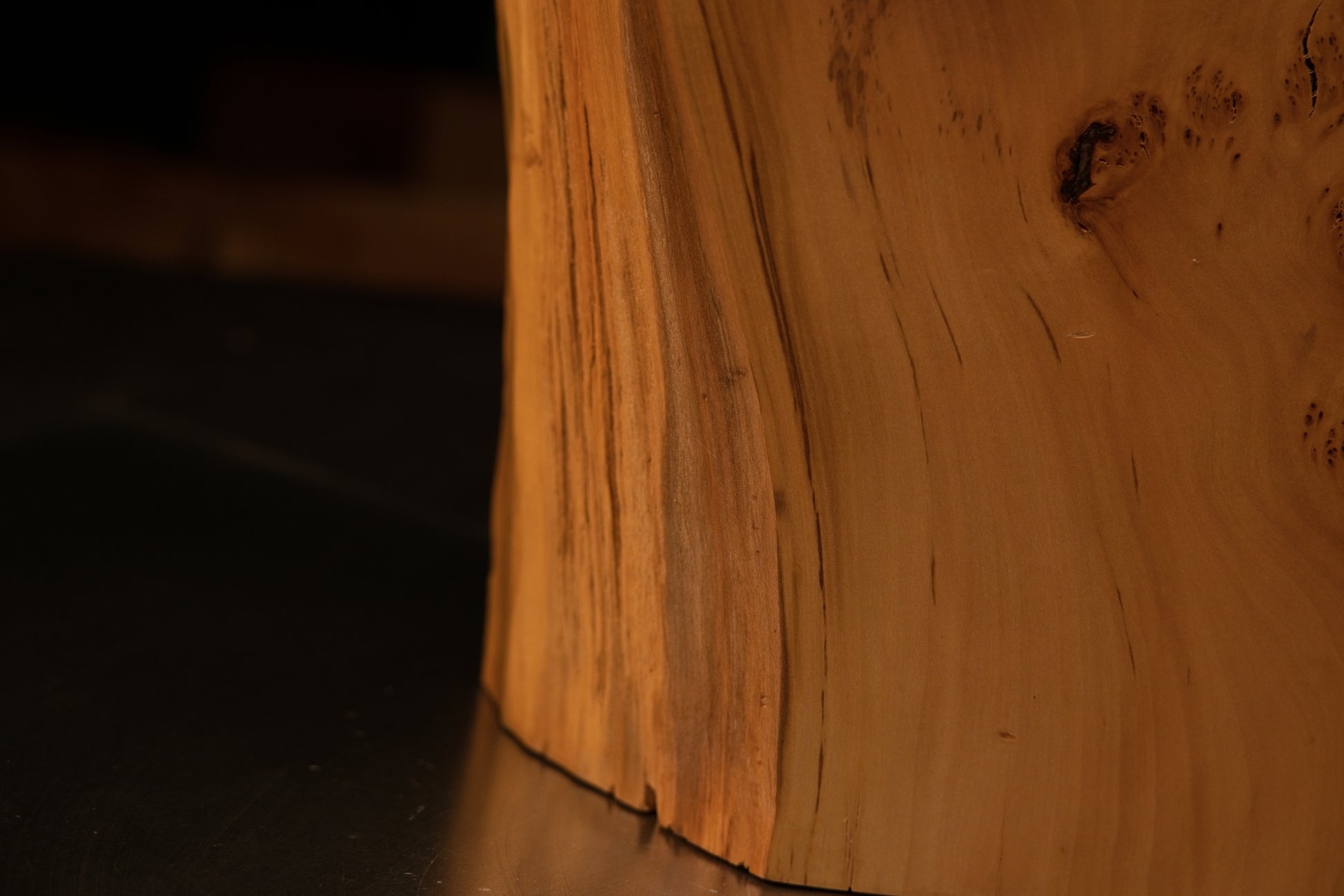 Close inspection of sweeping wood grain curving downward toward the precision-cut flat foundation of a floor-heating safe slab.   