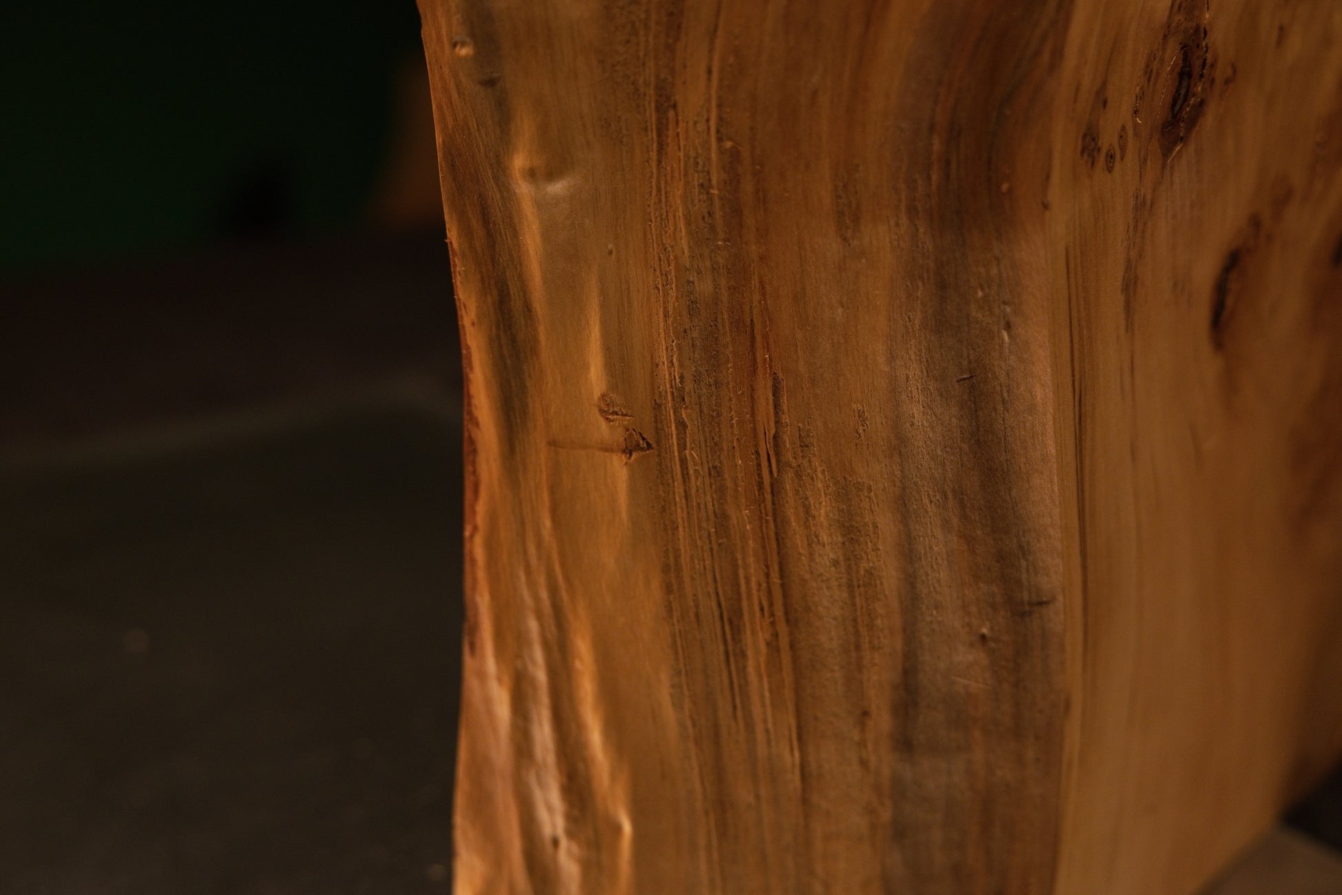 Macro photography highlighting straight vertical golden grain lines across the smooth flat face of a premier gallery-quality wood item.   