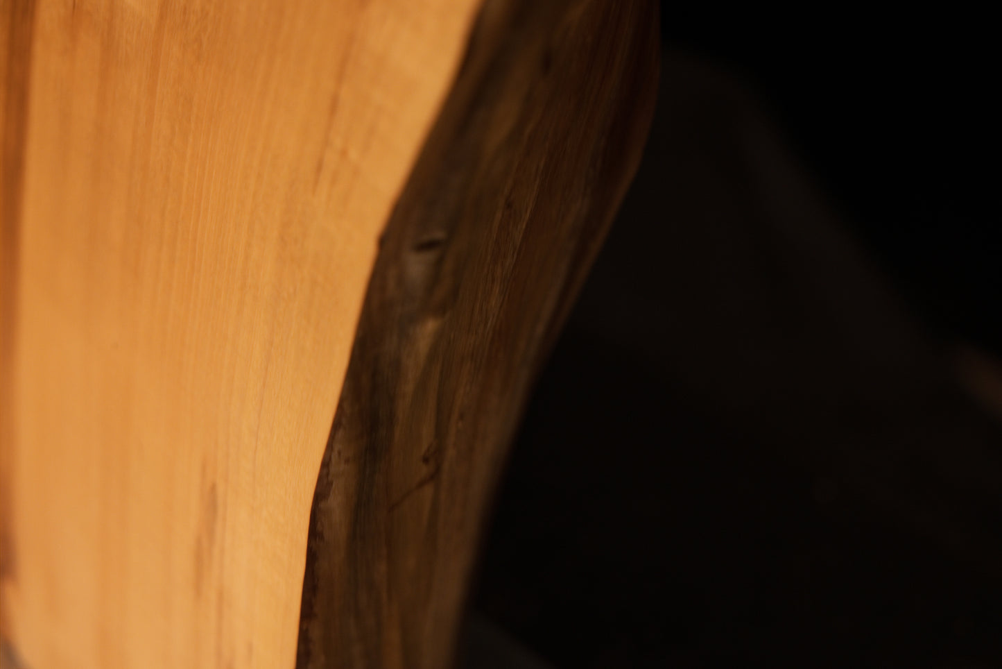Close-up capturing a smooth botanical corner arc that showcases warm golden wood chatoyancy on an elite architectural monolith.   
