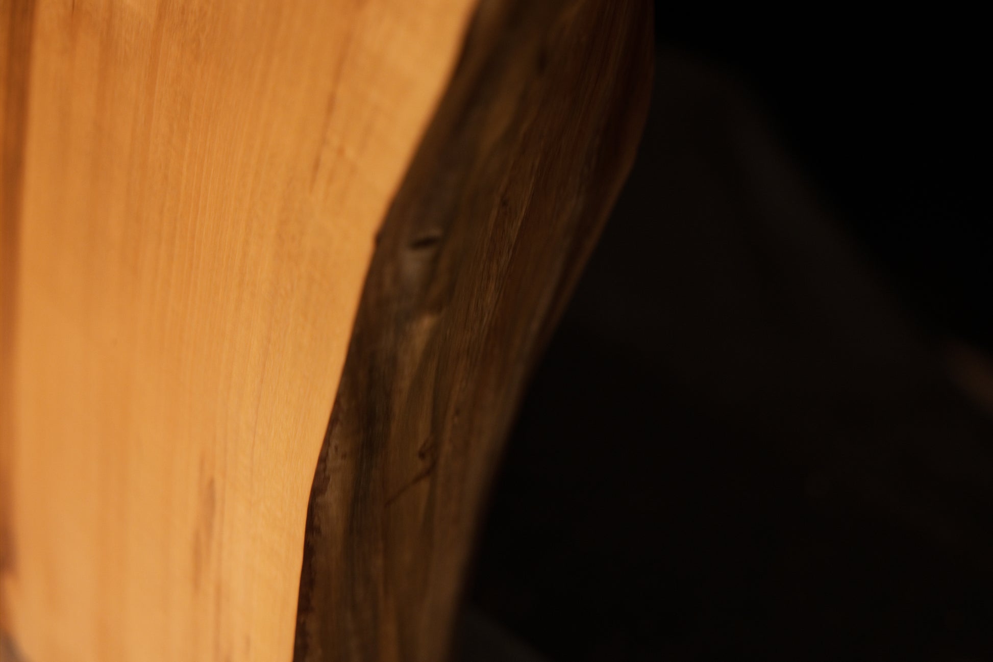 Close-up capturing a smooth botanical corner arc that showcases warm golden wood chatoyancy on an elite architectural monolith.   