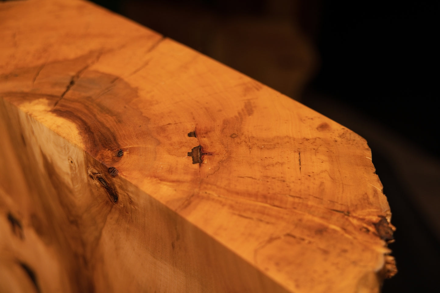 Angled close-up of the upper precision cut surface on a climate-stable structural wooden block showing a small organic inclusion.   