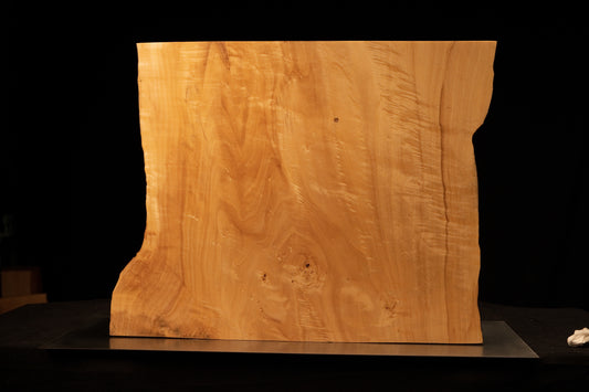 Front perspective of a climate-stable architectural wood block displaying a smooth golden face and wavy side botanical edges.    