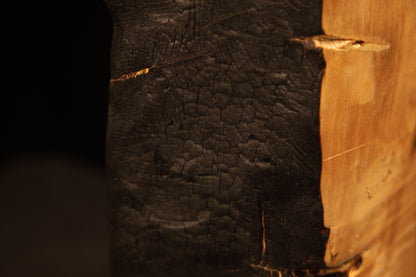 Top corner perspective highlighting a flat precision cut intersecting the dark charred edge of an epoxy-free structural block.    