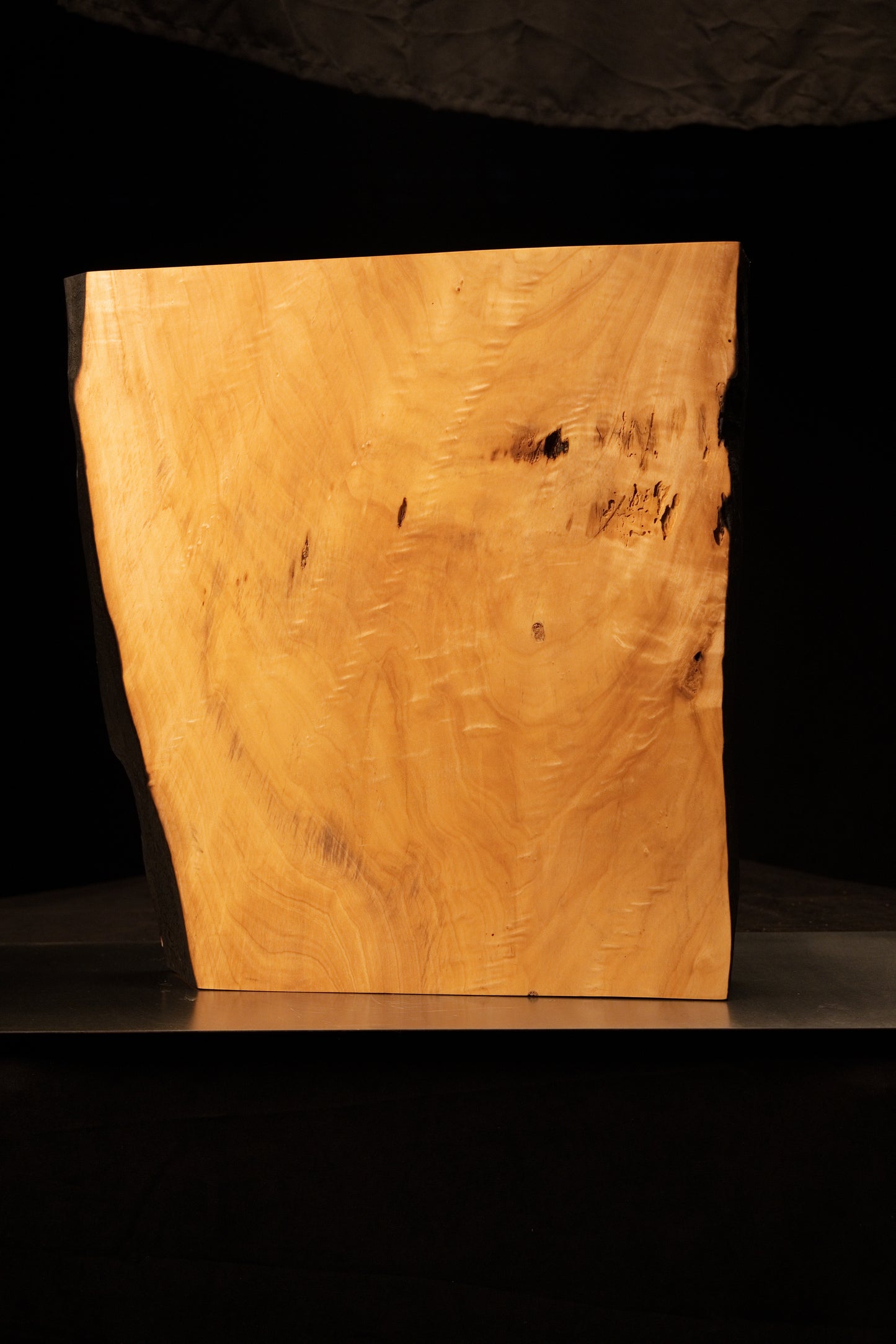 Full angled profile of a fully stabilized structural timber slab revealing sweeping natural chatoyancy and a dark central knot.[cite: 3, 4]