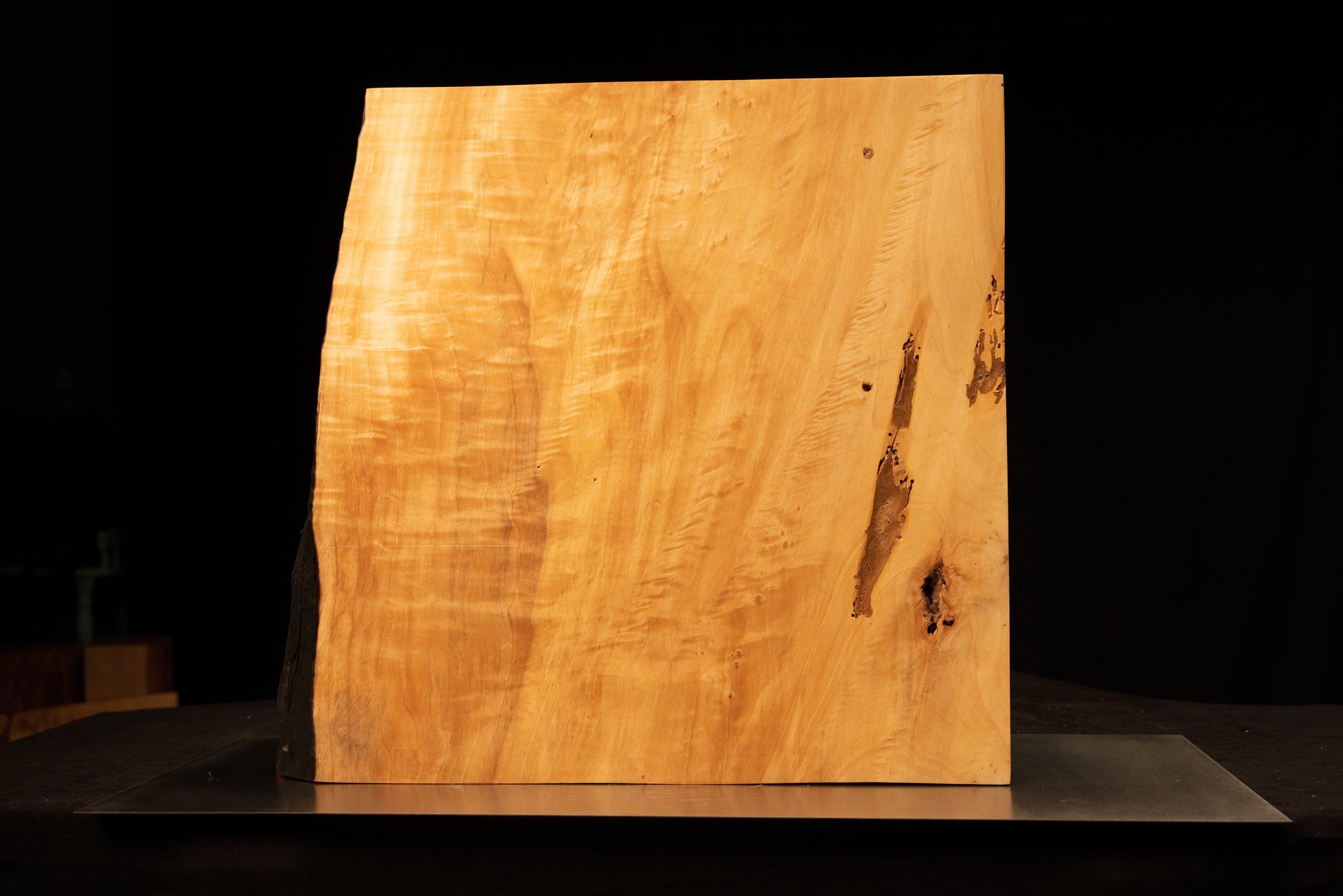 Front view of a wide climate-stable architectural slab displaying sweeping golden grain and a dark central vertical split.  